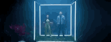 a man and a woman are dancing in a square in a dark room .