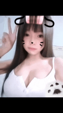 the girl is wearing a white tank top with a cat face on her face .