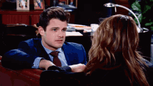 a man in a suit and tie talking to a woman
