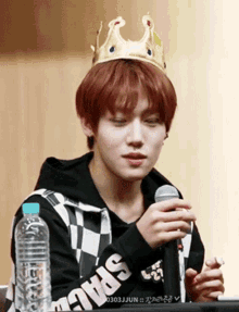 a young man wearing a crown and holding a microphone