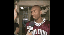 a man wearing an espn jersey is being interviewed by another man
