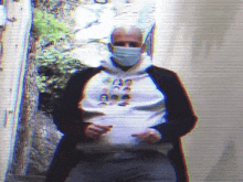 a man wearing a mask is holding a piece of paper in his hand