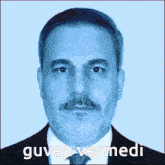 a man with a beard and mustache is wearing a suit and tie and the caption guven vermedi