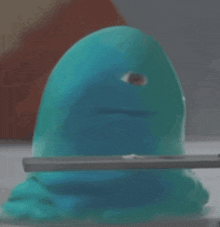 a blue toy with a big eye is being held by a person