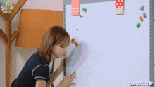 a woman stands in front of a white board that says aespagifs on the bottom