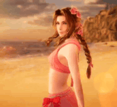 a woman in a pink bikini with flowers in her hair is standing on a beach