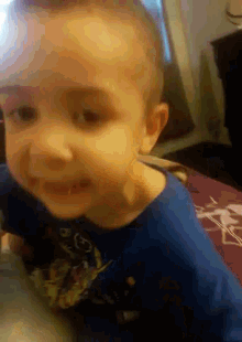a little boy wearing a blue shirt that says ' a ' on it