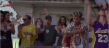a group of people are dancing and one man is wearing a lakers jersey .