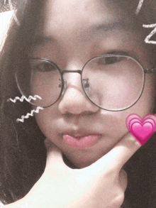 a girl wearing glasses has a pink heart on her face