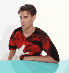 a young man wearing a red and black shirt with a picture of a woman on it