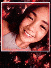 a girl is smiling in front of a red background with butterflies