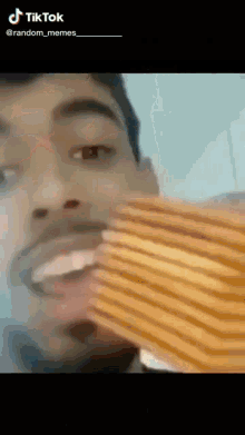 a man is eating a sandwich with his mouth open in a tik tok video .