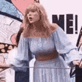 a woman in a blue dress is standing in front of a glass railing .