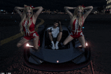 a man sits in a car surrounded by two women