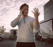 a man talking on a cell phone while waving