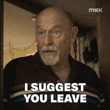 a man with a beard is standing in a doorway and says " i suggest you leave "