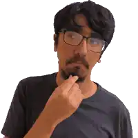 a man with glasses and a beard holds his hand to his chin