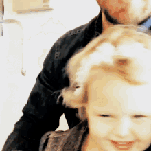 a man brushes a little girl 's hair in a blurry photo