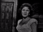 a black and white photo of a woman wearing a dress