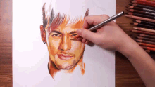 a person is drawing a man 's face with colored pencils on a piece of paper