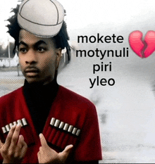 a man with a hat on his head and a broken heart behind him that says mokete motynuli piri yleo