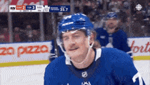 a hockey player wearing a blue jersey with the number 11 on it