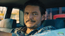 a man in a plaid shirt is sitting in the back seat of a car with the word tales in the background