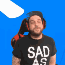 a man wearing headphones and a shirt that says " sad as "