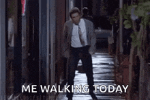 a man in a suit and tie is walking down a sidewalk with the words `` me walking today '' .