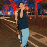 a group of people are dancing on a sidewalk in front of trees .