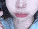 a close up of a woman 's face with a pink lipstick on her lips .