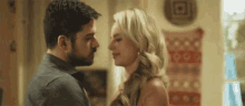 a man and a woman are looking at each other in a room .