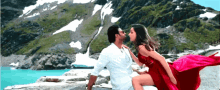 a man and a woman kissing in front of mountains