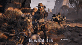a man in a cowboy hat is standing next to a cactus in a video game and says is what it is