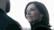 a man and a woman are looking at each other and the woman is smiling .