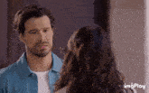 a man and a woman are looking at each other with imgplay in the lower right corner