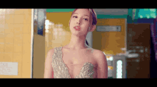 a woman in a very revealing dress is standing in a hallway looking at the camera .