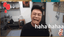 a man wearing glasses is laughing in a room with the words haha hahaa on the screen