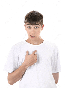 a young man in a white t-shirt is pointing to his chest