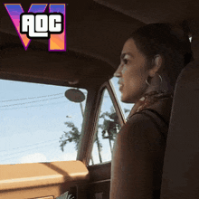 a woman sits in the driver 's seat of a car with a logo for aoc in the background