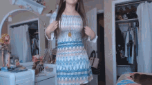 a woman in a dress is standing in front of a mirror in a bedroom