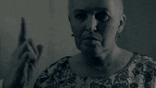 a woman wearing a floral shirt is pointing her finger