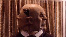 a statue of a bald man with a mask on his face