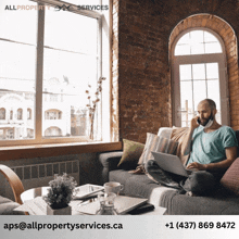 a man is sitting on a couch using a laptop and talking on a phone