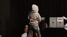 a woman in a white skirt is being hugged by a man in a grey hoodie with a korean writing on it