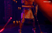 a person in a knight costume is holding a sword in a dark room with candles behind them .