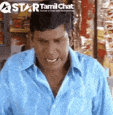 a man in a blue shirt stands in front of a star tamil chat logo