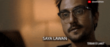 a close up of a man wearing glasses and the words saya lawan on the bottom