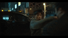 two men are standing next to each other on a city street .