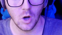 a close up of a man 's face with glasses and a beard .